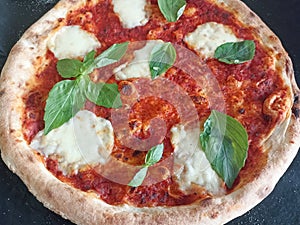 Pizza Margherita with mozzarella, tomato sauce and basil. Fresh and crispy.