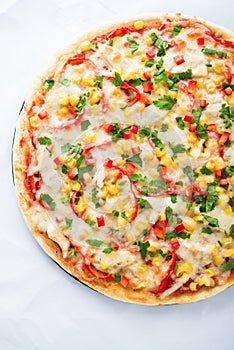 Pizza with mozzarella cheese, chicken, sweet corn, sweet pepper and parsley on white background top view