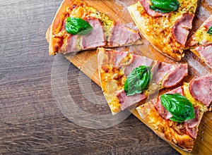 Pizza with Mozzarella cheese, ham, tomato sauce, pepper, Spices and Fresh basil. Italian pizza on wooden table