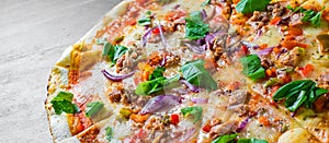 Pizza with Mozzarella cheese, onion, tuna fish, tomato sauce, pepper, basil. Italian pizza on wooden table