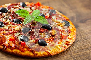 Pizza with Mozzarella cheese, salami, pepper, ham, pepperoni, olives, Spices and Fresh Basil. Italian pizza