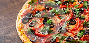 Pizza with Mozzarella cheese, salami, pepper, pepperoni, Tomatoes, olives, Spices and Fresh Basil. Italian pizza