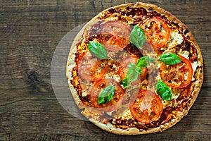 Pizza with Mozzarella cheese, Tomatoes, pepper, Spices and Fresh Basil. Italian pizza. Pizza Margherita or Margarita. on wooden ba