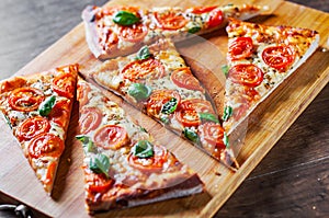 Pizza with Mozzarella cheese, Tomatoes, pepper, Spices and Fresh Basil. Italian pizza. Pizza Margherita or Margarita on wooden tab
