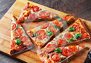 Pizza with Mozzarella cheese, Tomatoes, pepper, Spices and Fresh Basil. Italian pizza. Pizza Margherita or Margarita on wooden tab