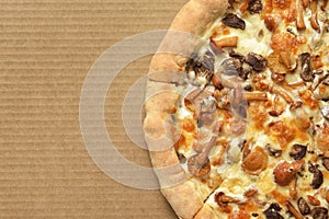 Pizza with mushrooms on corrugated fiberboard background photo