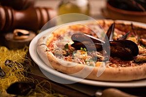 Pizza with mussels and shirmps on wooden board. sea food background