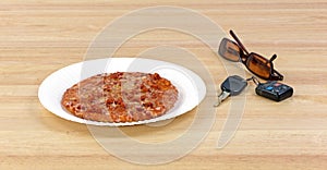 Pizza next to car keys and sunglasses