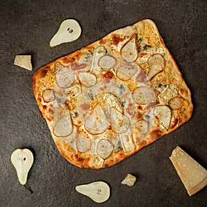 Pizza with pear, Gorgonzola cheese and parmesan cheese on gray stone. Mini pizza with pear slice cut out. Top view