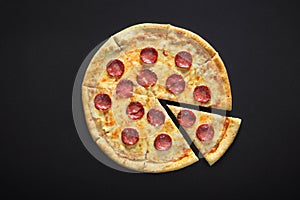 Pizza peperoni on black stone background