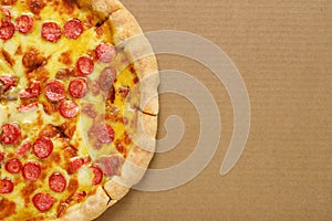 Pizza pepperoni on brown corrugated fiberboard background photo