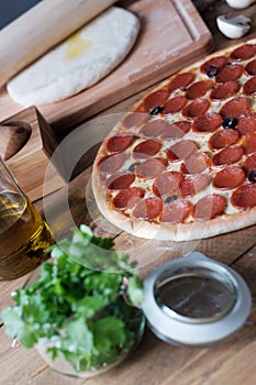 Pizza pepperoni with salami sausage and ingredient on the wooden table in rustik style