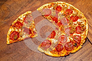 Pizza pie with a quarter removed to demonstrate math fractions. photo