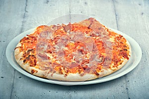 Pizza Prosciuto on white wooden background photo