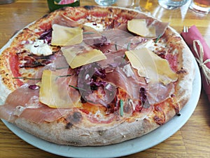 Pizza with prosciutto cheese and red radish on a plate