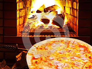 Pizza with prosciutto cotto and open fire in oven photo