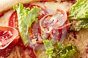 Pizza with prosciutto, lettuce salad and parmesan