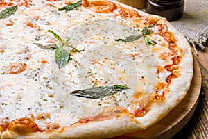 Pizza Quattro formaggi with mint on table