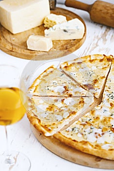 Pizza quattro formaggi on a wooden board .four cheese pizza and fresh ingredients for a four cheeses Italian pizza