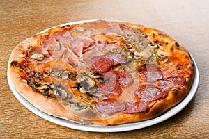 Pizza quattro stagioni is a variety of pizza in Italian cuisine that is prepared in four sections photo