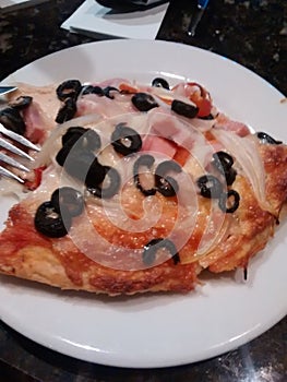 PIZZA RACION IN WHITE DISH READY TO EAT. WITH HAM CHEESE CEBOLLA AND NAPOLI SAUCE photo