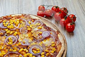 Pizza with red sauce, ham, mozarella, corn and onion rings detail