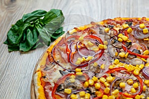 Pizza with red sauce, ham, mozarella, corn, onion rings, red bell pepper, mushroom detail