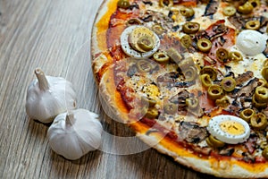 Pizza with red sauce, mozarella, ham, mushroom, boiled egg, green olives detail