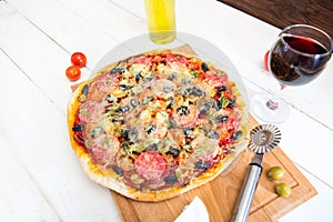 Pizza and red wine on wooden table background. Top view with copy space