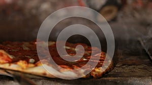 Pizza rotating and cooking in brick oven