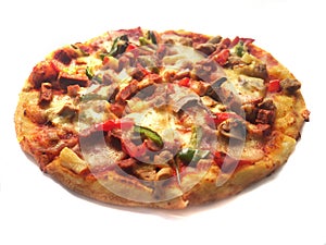 Pizza in round shape, topped with meat, ham, mushroom and veggies