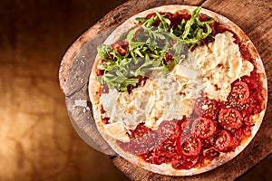 Pizza with rows of tomatoes, cheese and arugula