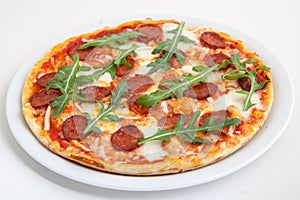 Pizza with salami, cheese and arugula