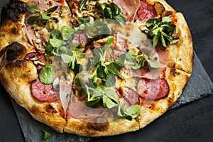 Pizza salami,cheese and ham with cornsalad leaves