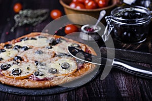 Pizza with salami, mozzarella, olives and basil