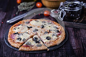 Pizza with salami, mozzarella, olives and basil