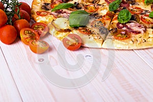 Pizza with Salami Vegetables and Spices on a white wooden background with copy space.