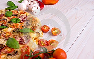 Pizza with Salami Vegetables and Spices on a white wooden background with copy space.