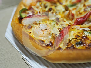 Pizza Seafood Cocktail pan on top with Shrimp, Crab Sticks, Ham, Pineapple and Sauce in paper box, fast food