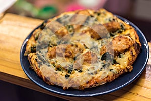 Pizza served on wooden circle board