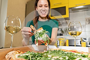 Pizza on table two glasses of white wine at home