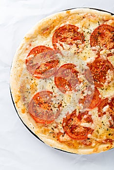 Pizza with tomato, cheese and dry basil on white background top view