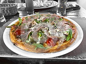 Pizza with tomato, rocket, cheese and ham