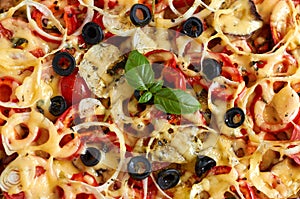 Pizza with tomatoes, bell pepper, onion, black olives, cheese and basil texture background. Pizza texture surface. Pizza texture