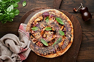 Pizza. Traditional Bacon pizza with ham, mushrooms, pickled cucumber and cheese and cooking ingredients tomatoes basil on wooden