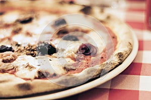 Pizza with tuna fish, mozzarella, tomato sauce on the plate â€“ traditional sicilian