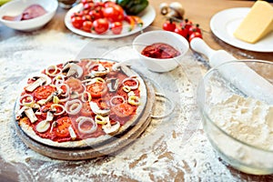 Pizza and various ingredients on table