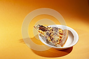 Pizza on white plate, isolated on orange.