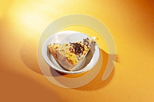 Pizza on white plate, isolated on orange.