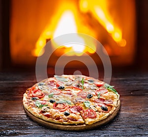 Pizza. Wood-fired oven on the background. photo